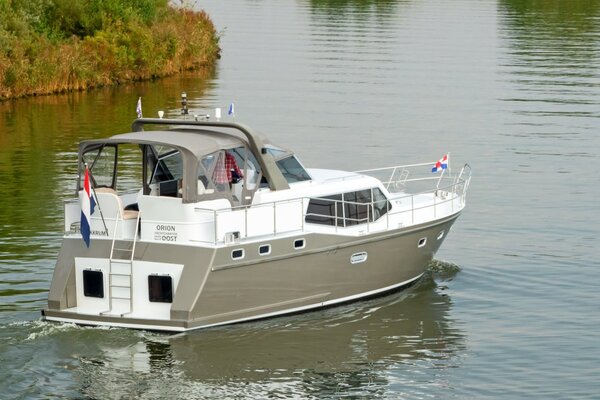 Draufsicht auf eine Motoryacht, die durch die Wasserstraße in Friesland segelt 