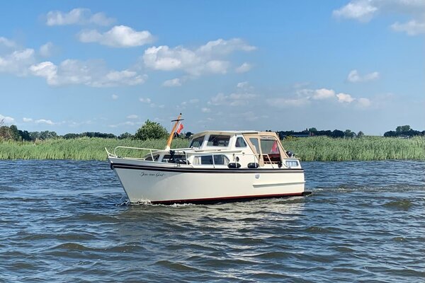 Motorboot im Bootsurlaub in Friesland, mit Schilf im Hintergrund 